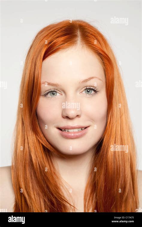 Portrait Of A Friendly Smiling Young Red Haired Woman In Front Of
