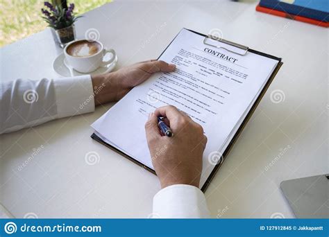 Hands Of Business Man Signing The Contract Document With Pen On Desk