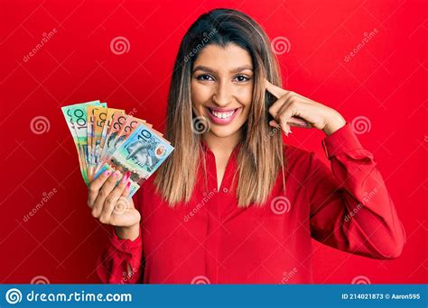 Beautiful Brunette Woman Holding Australian Dollars Smiling Pointing To Head With One Finger
