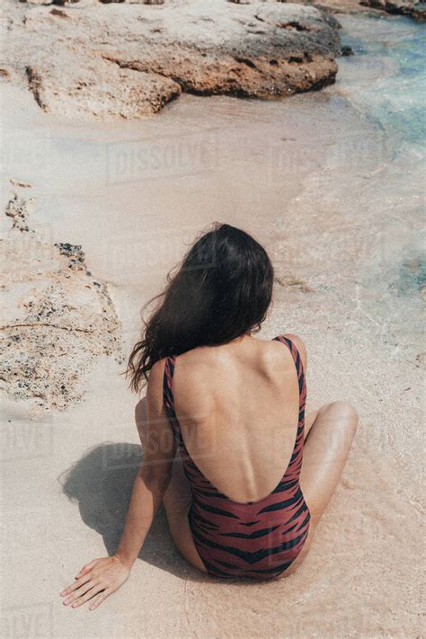 Rear View Of A Woman Sitting On Beach Stock Photo Dissolve