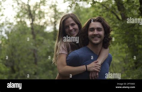 Carefree Young Couple Pose In Forest Man Gives Girlfriend A Piggyback