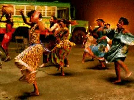 A Group Of People Dancing In Front Of A Green Bus