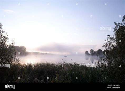 Morning Mist Over Lake With Sailboat 1 Stock Photo Alamy