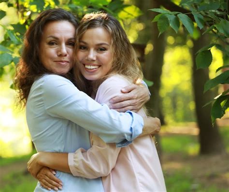 premium photo lifestyle and people concept mature mother and adult daughter hugging in the park