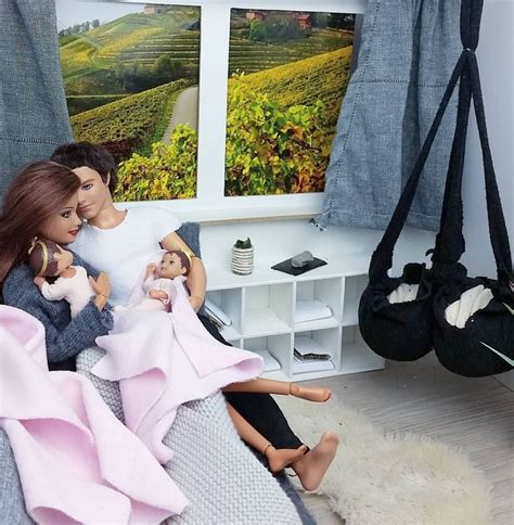 Two Dolls Are Sitting On A Bed In Front Of A Window