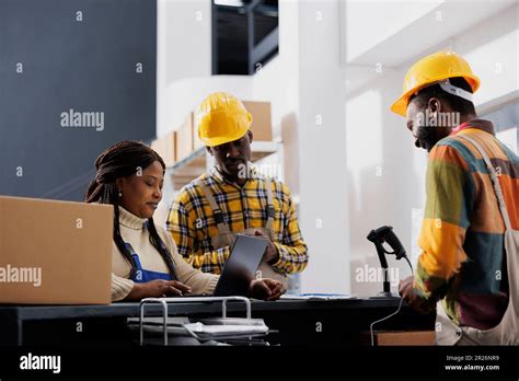 Post office employees making electronic invoice for customer parcel