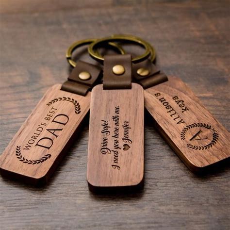 Three Wooden Key Chains With Engraved Labels On Them