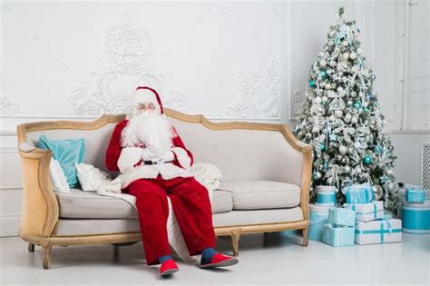 Traditional Santa Claus Sitting On The Couch And Having A Rest