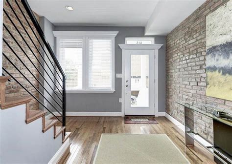 Home Entryway With Gray Paint White Door Wood Floor And Brick Walls
