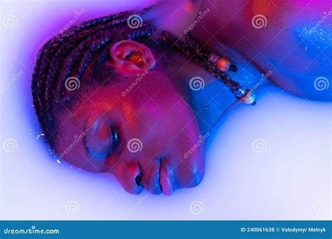 profil vue du visage féminin de la fille africaine dans le bain de lait avec doux glowi blanc