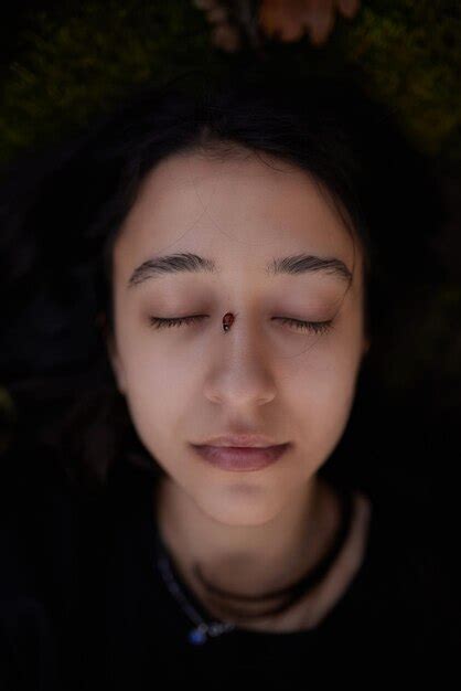 Una Chica Con Los Ojos Cerrados Una Mariquita En La Cara Foto Premium