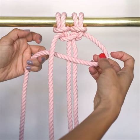 Two Hands Are Tying A Pink Rope Together