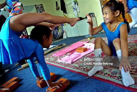 A Mongolian Girl Tickles Her Friends Foot As She Balances During A