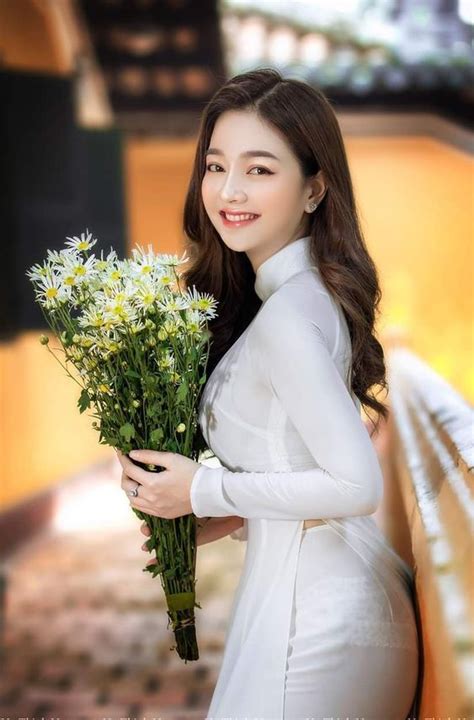 The Woman Is Holding Flowers In Her Hand