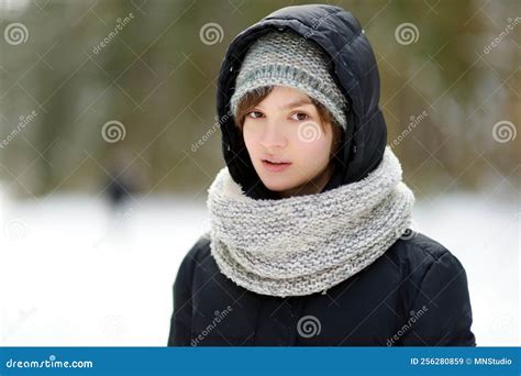 jovencita linda divirtiéndose en un paseo por el bosque de pinos cubierto de nieve en un frío