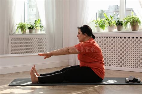 Overweight Mature Woman Stretching On Floor At Home Stock Image Image