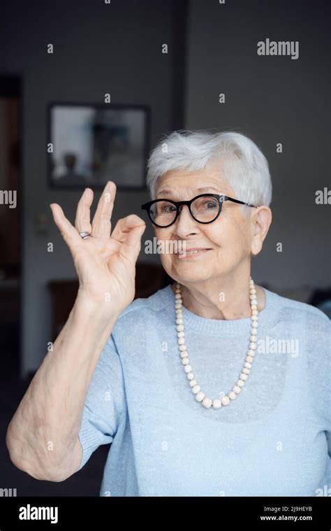 Smiling Senior Woman Wearing Eyeglasses Showing Ok Sign Gesture Stock