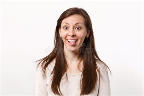 Portrait Of Cheerful Funny Crazy Young Woman In Light Clothes Looking Camera Showing Tongue