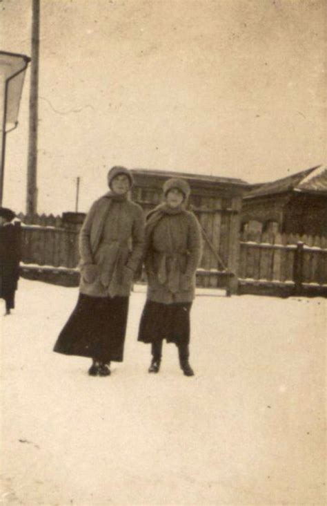 An Old Photo Of Two People Standing In The Snow