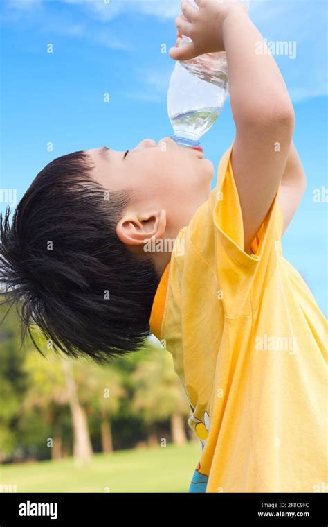 Little Asian Boy Drinking Water From Plastic Bottle With The Thirsty