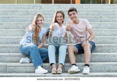 Successful College Students Gesturing Thumbs Making Stock Photo