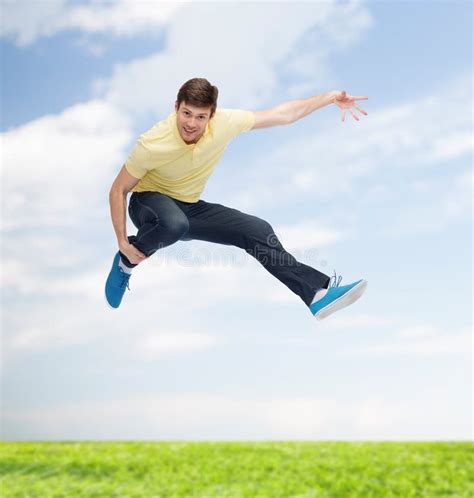 Smiling Young Man Jumping In Air Stock Photo Image Of Motion Arms