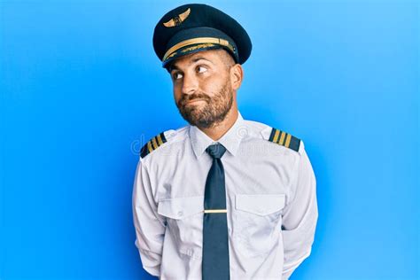 Handsome Man With Beard Wearing Airplane Pilot Uniform Smiling Looking