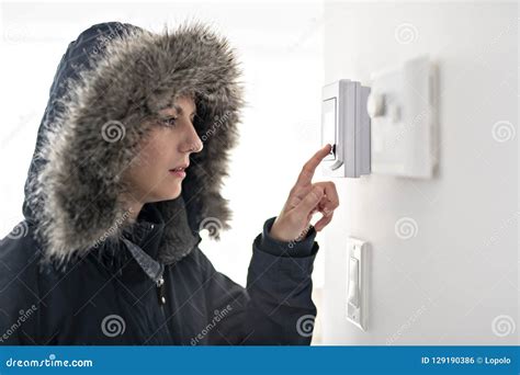 Woman With Warm Clothing Feeling The Cold Inside House Stock Photo