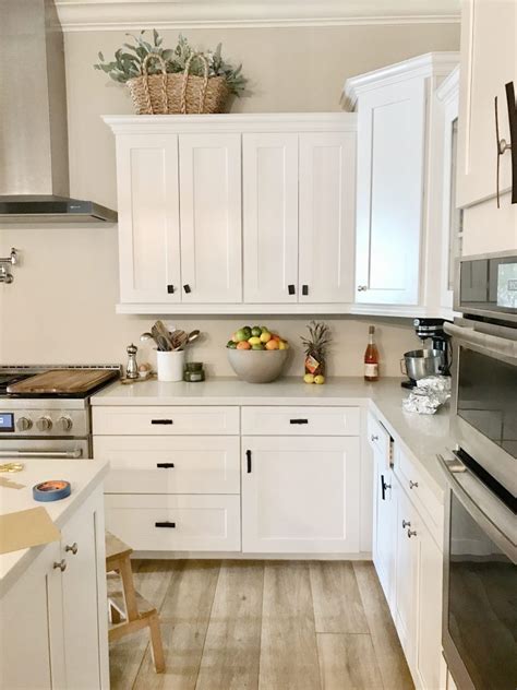 Black cabinet handles and sink faucet can provide contrast against the white farm sink and cabinets. Black Kitchen Hardware Update | Just Destiny