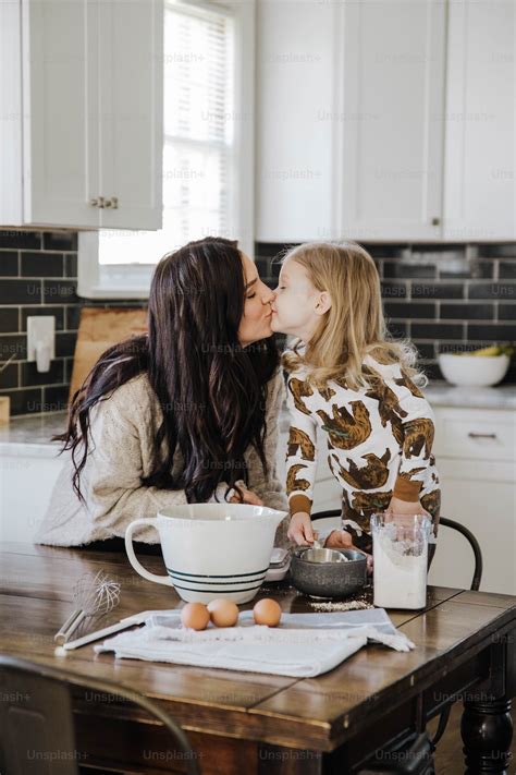 Foto Una Madre Besando A Su Hija En La Cocina Madre Imagen En Unsplash