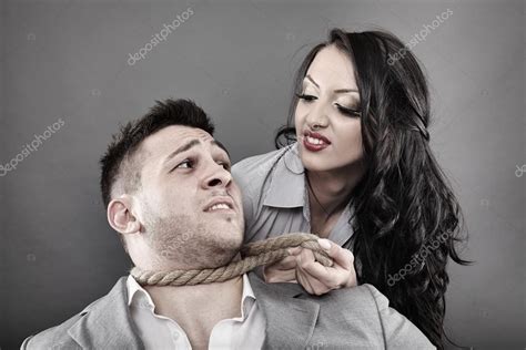 Man Being Tied By His Neck With A Rope By A Woman Stock Photo By