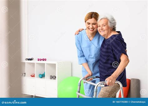 Caretaker Helping Elderly Woman With Walking Frame Stock Photo Image