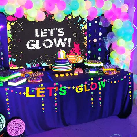There Is A Table With Balloons And Cake On It That Says Lets Glow