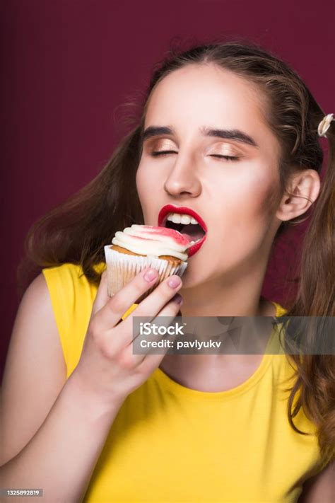 Hungry Brunette Model Biting Yummy Cake With Cream Over A Red