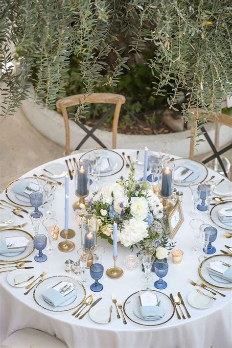 The Table Is Set With Blue And White Plates Silverware Flowers And