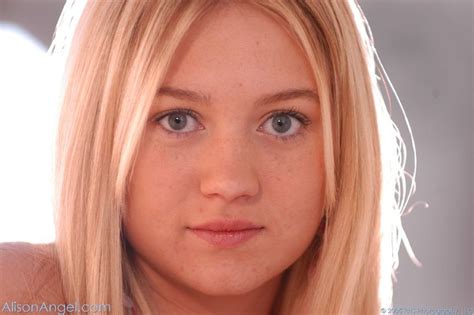 A Woman With Blonde Hair And Blue Eyes Looking At The Camera While