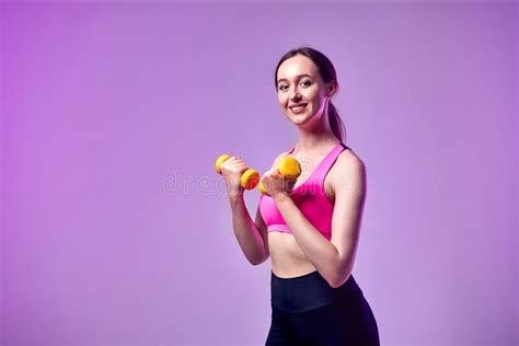 Young Beautiful Sports Girl In Leggings And A Top Does Exercises With Dumbbells Healthy