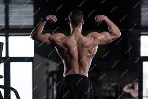 Hombre Musculoso Flexionando Los Músculos De La Espalda Pose Foto Premium