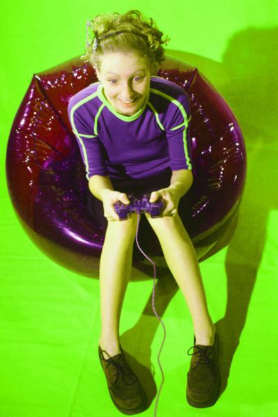 Young Woman Sitting On Black Bean Bag Chair Playing Video Game Free