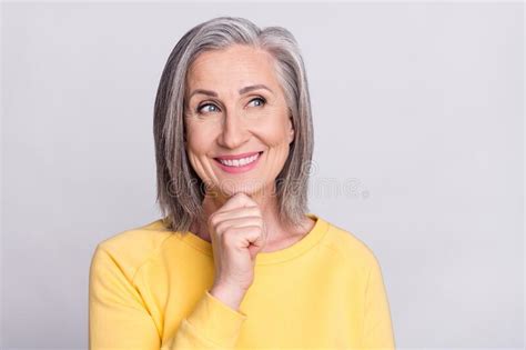 Photo Of Cute Dreamy Mature Lady Wear Yellow Clothes Arm Chin Looking Empty Space Smiling