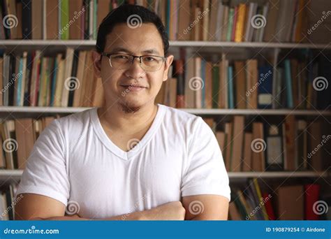 Portrait Of Cheerful Asian Male Librarian Smiling Man Standing Against