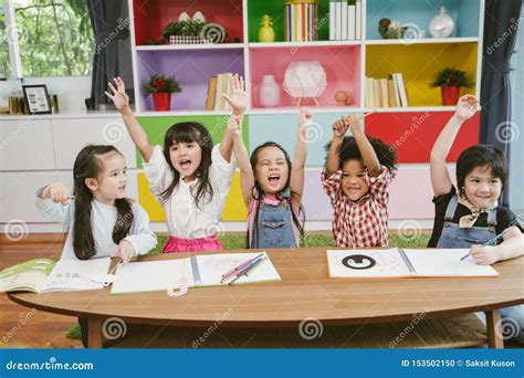 Group Of Little Preschool Kids Hands Up In Class Portrait Of Children