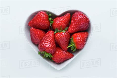 Strawberries In Heart Shape Bowl On White Background Stock Photo