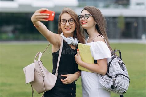 Two Young Girls Taking Selfie Self Portrait Photos On Smartphonefemale
