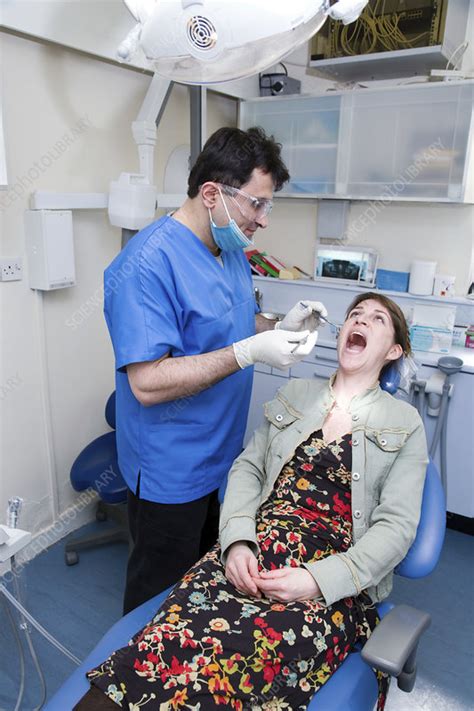 Dentist Carrying Out Dental Treatment On A Patient Stock Image C046