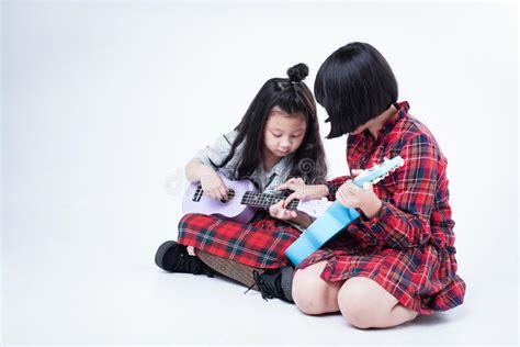 Elder Sister Holding Maracas In Hand And Try To Teach Naughty Younger