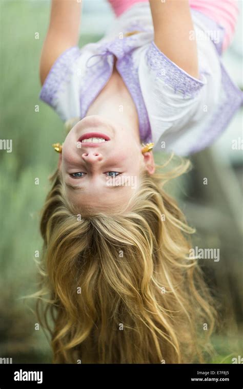 Caucasian Girl Hanging Upside Down Outdoors Stock Photo Alamy