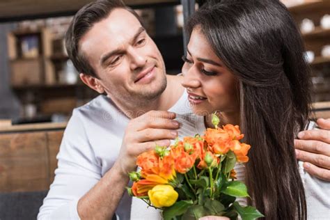 Smiling Man Embracing Girlfriend Holding Bouquet Of Flowers Stock Image