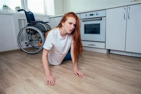 mujer pelirroja pelirroja cayendo y arrastrándose en busca de ayuda en la cocina foto premium