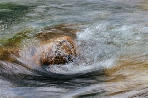 River Water Flowing Over Submerged Boulder Long Exposure By Stocksy